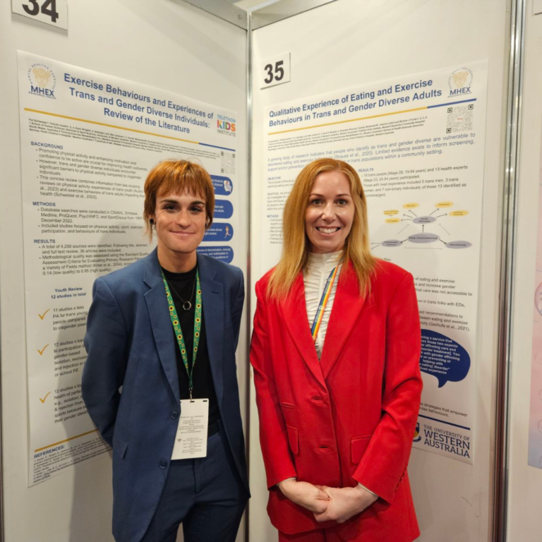 Researchers Felicity and Kai standing in front of posters at a conference